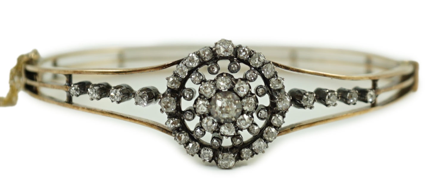 A Victorian gold and diamond cluster set hinged bangle